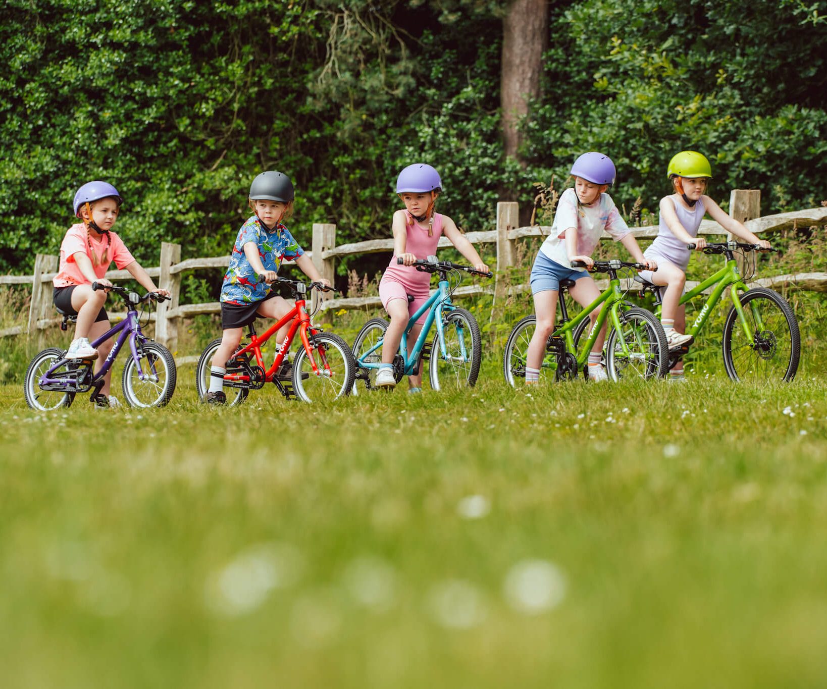 Group of 5 kids riding Yomo kids bikes in different colours 