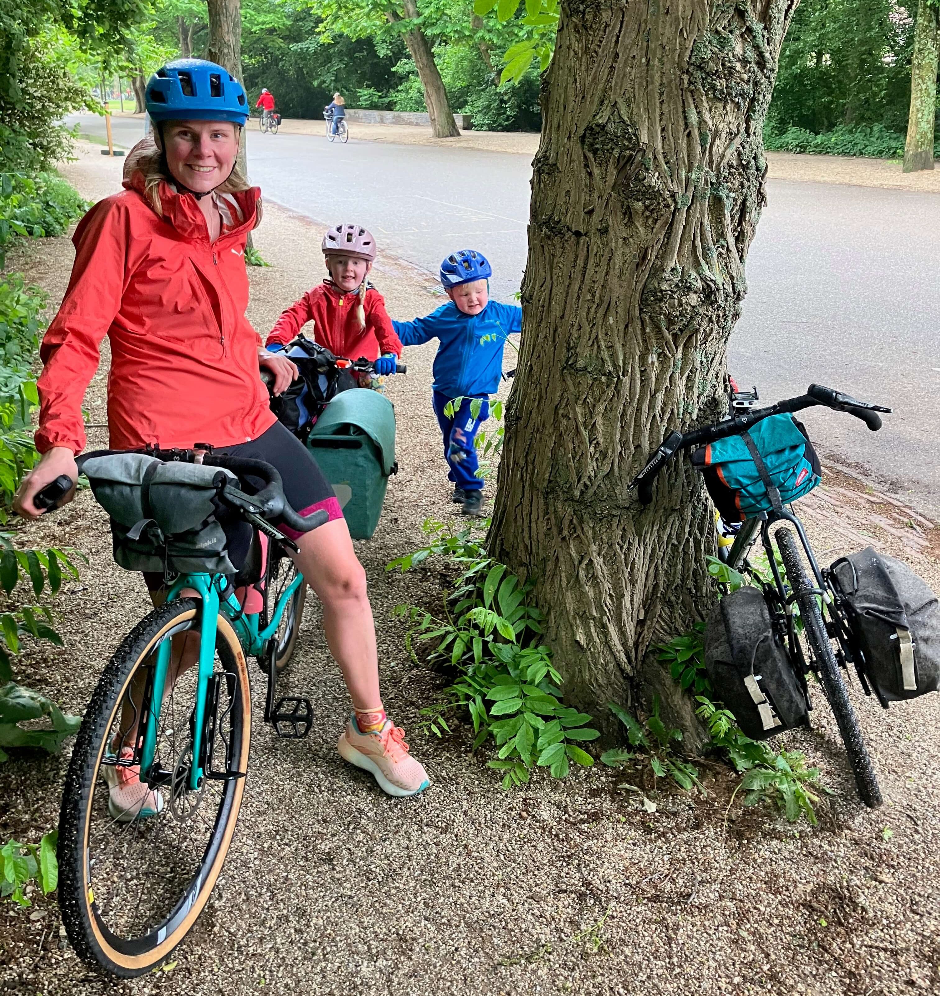 Family cycling holiday in the Netherlands - Adult with 2 children on a forest trail 