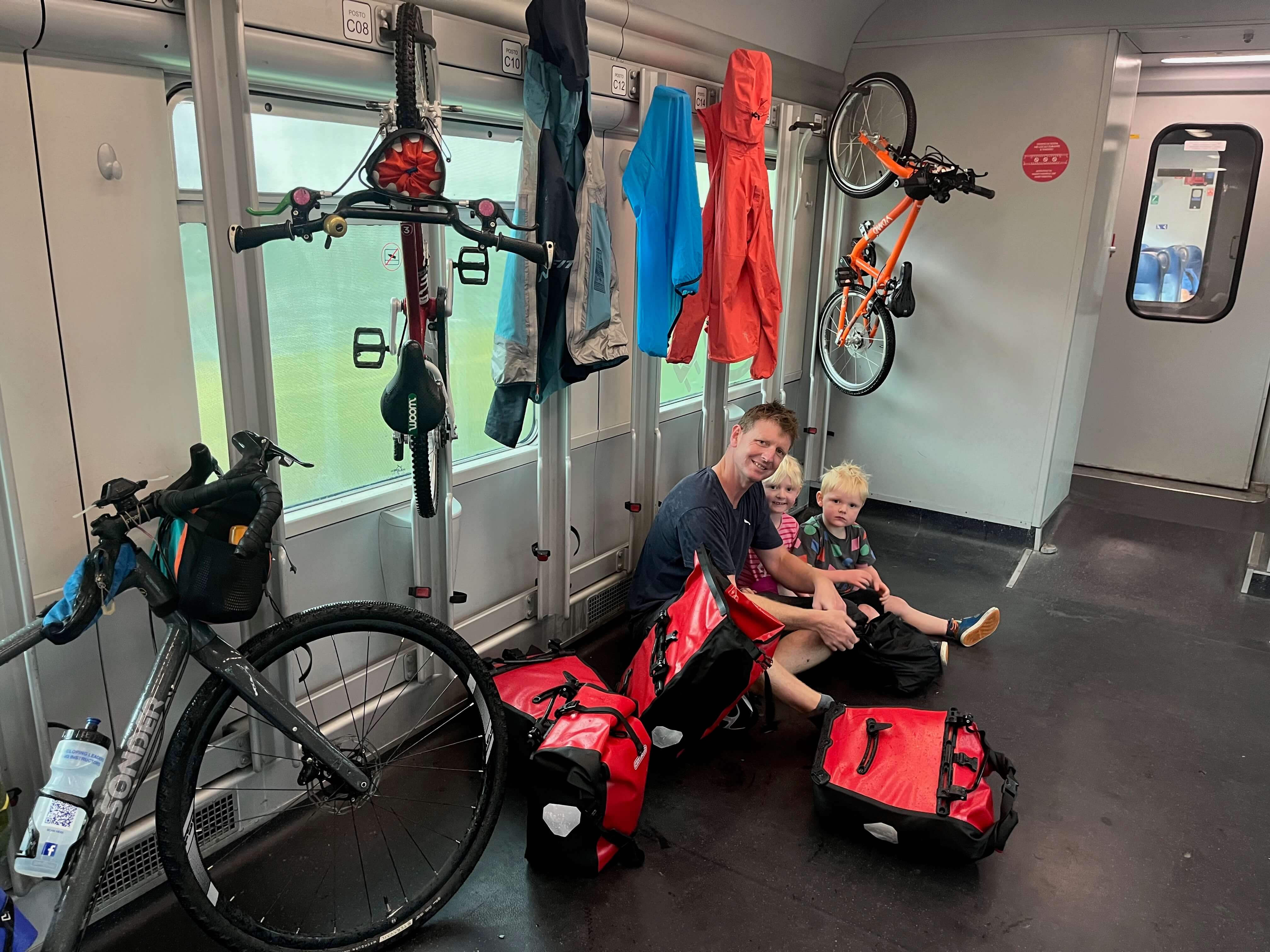 A family sat on a train with their bikes and all their cycling gear