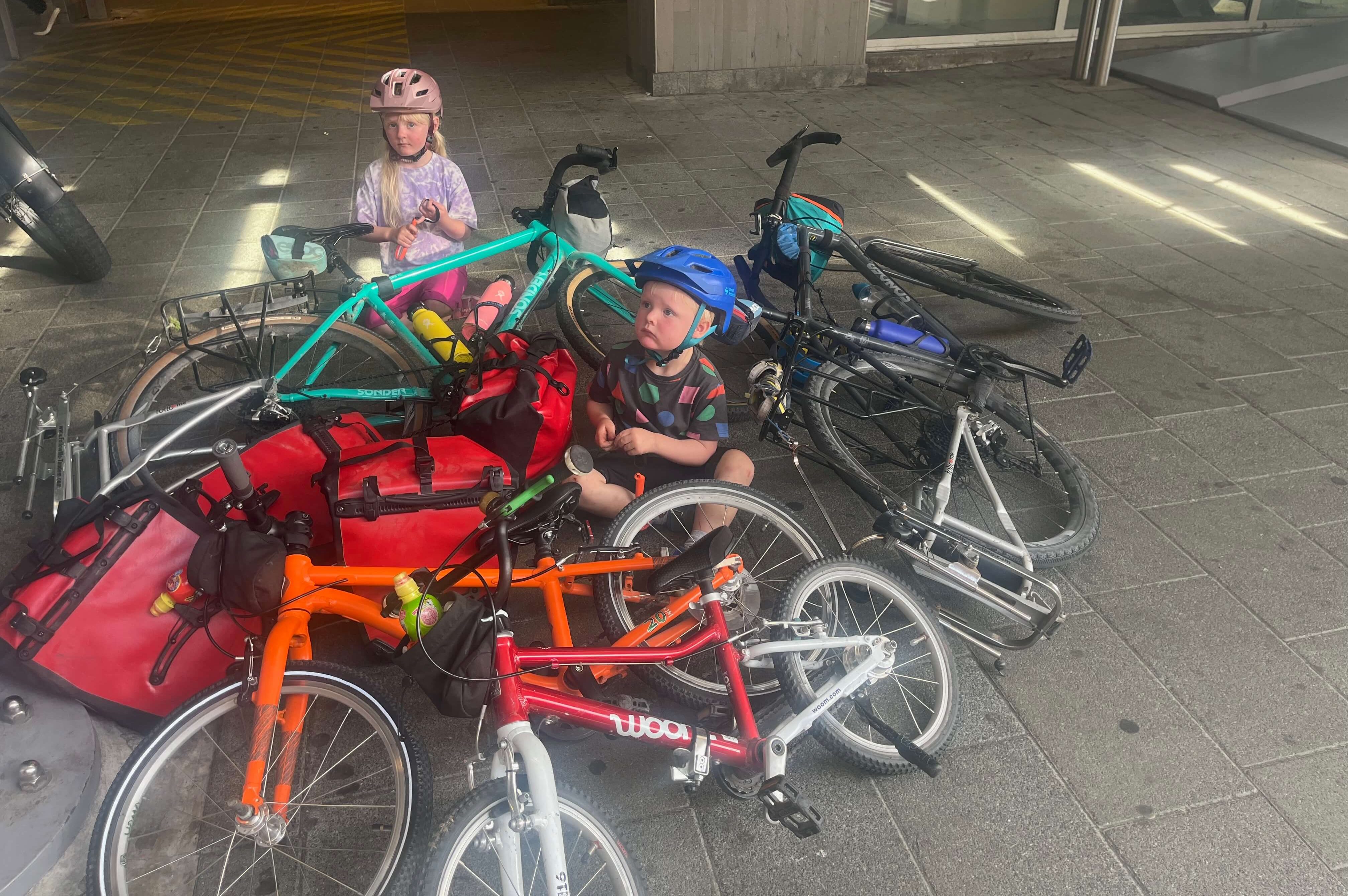 Holiday luggage on 4 family bikes on a trip in the Dolomites - 2 kids sat with the bikes