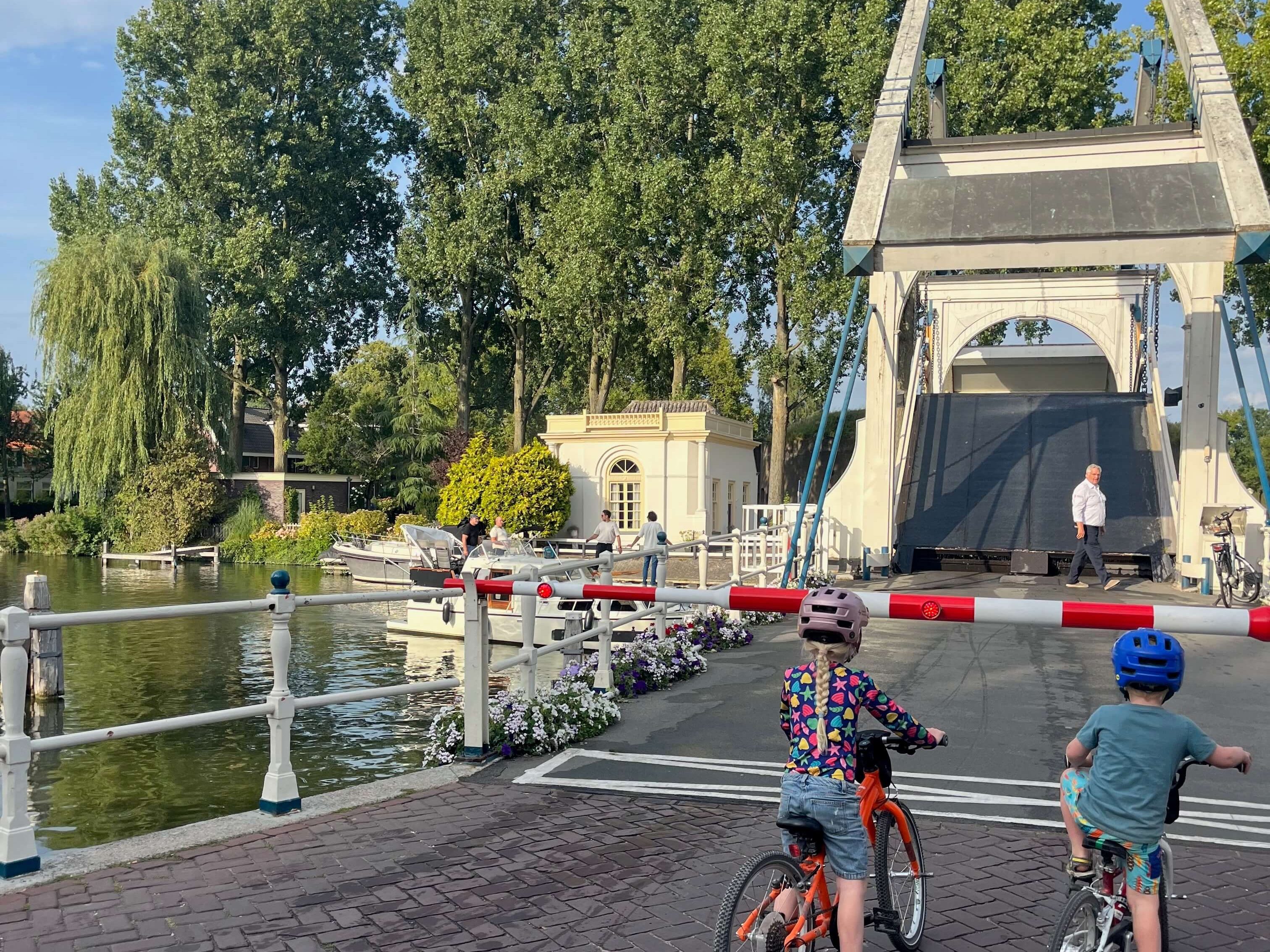 Two kids waiting at the lift bridges on their bikes in Weesp